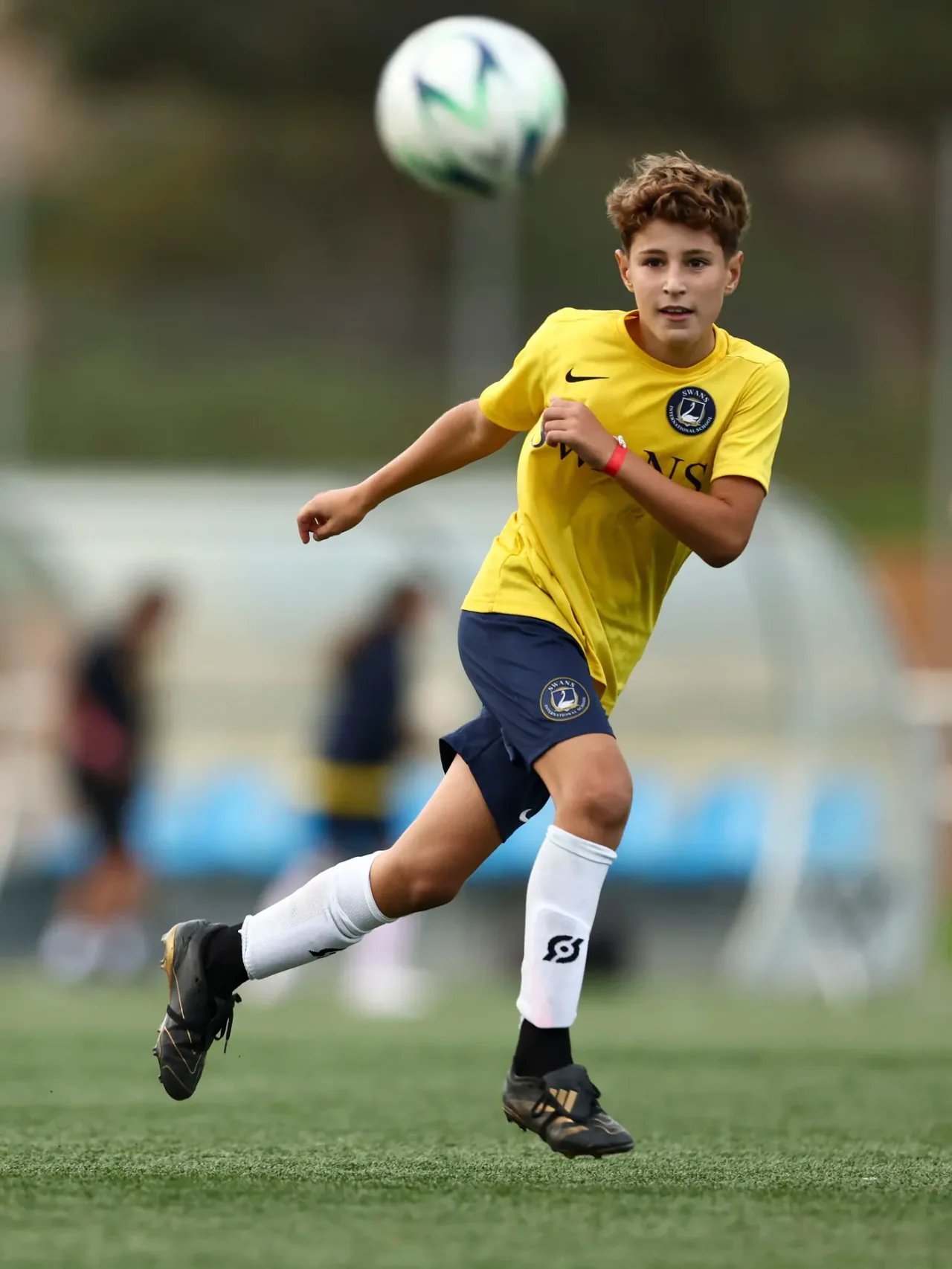 A young player chasing the ball at the WSG Football Cup
